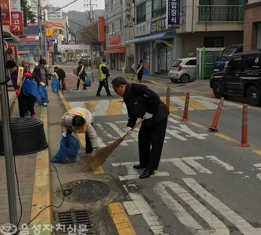 ▲ 구자평 금왕읍장과 마을 주민들이 도로에 버려진 생활쓰레기를 수거 하고 있다.